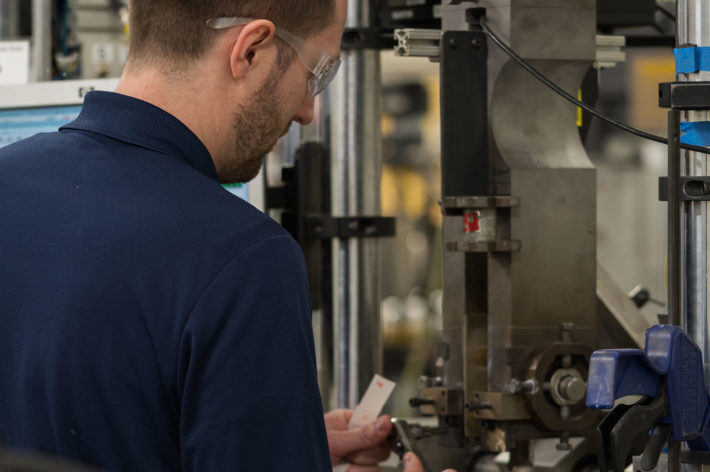 man with navy blue shirt working in machine shop
