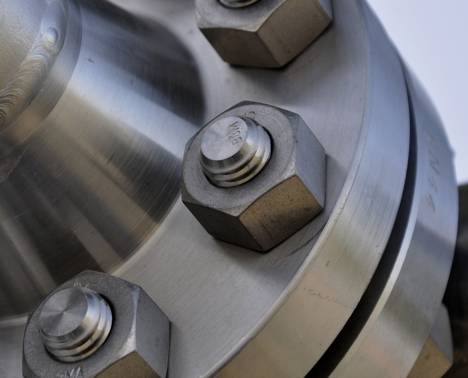 closeup of metal nut screwed onto a bolt holding two pieces together