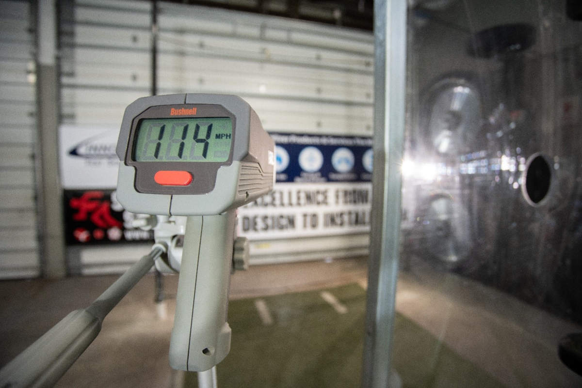 Baseball safety net speed gun test being performed from Sportsfield Specialties with a close up of a gray Bushnell radar gun.