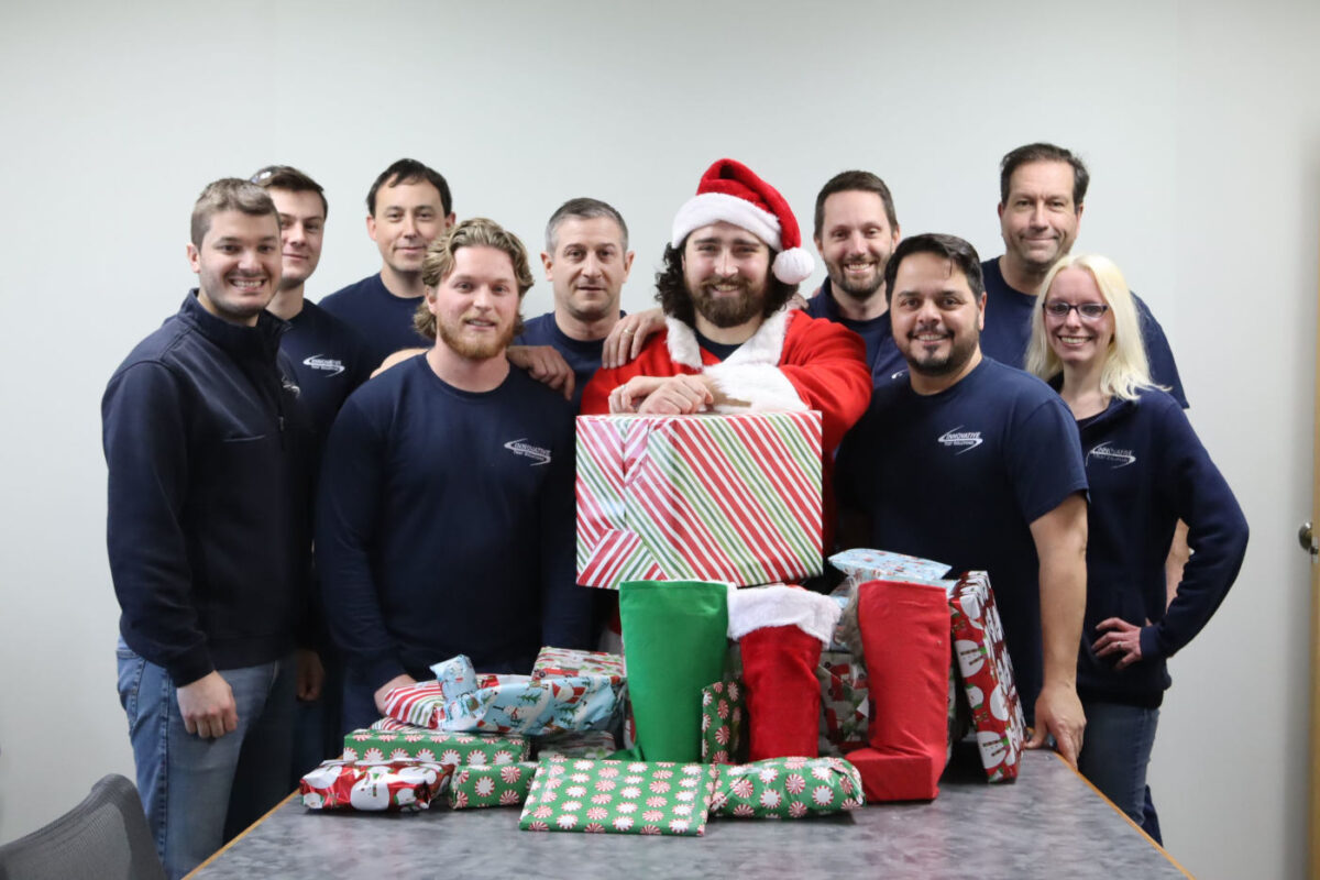 the Innovative Test Solutions engineering team pose for team photo after wrapping gifts for two families in Schenectady