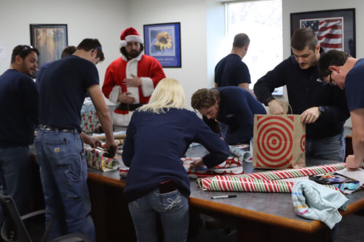 the Innovative Test Solutions engineering team wrapping gifts for two families in Schenectady to donate during the holiday season