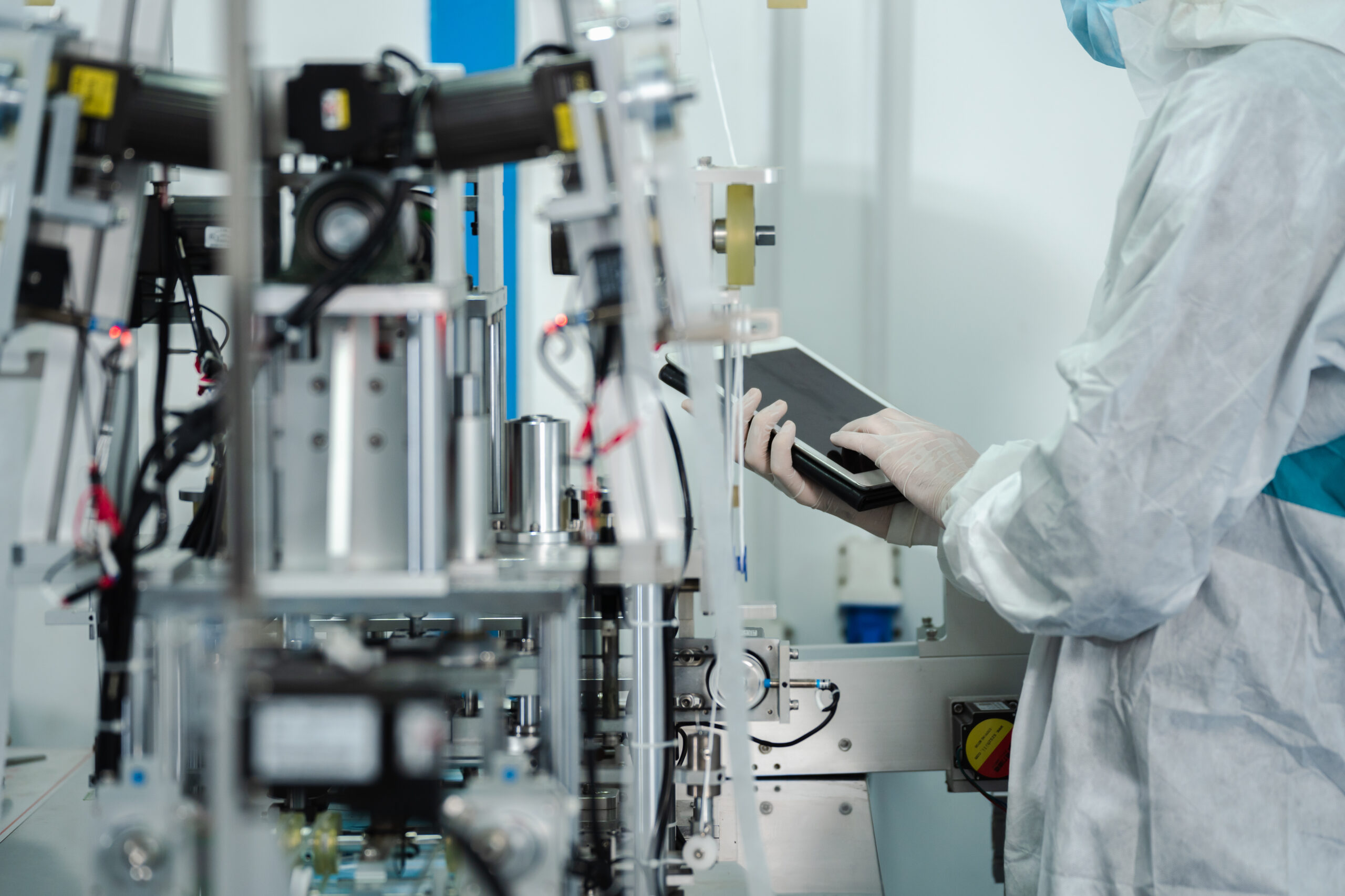 Bright hi-tech facility with Scientist in sterile clothing working in laboratory